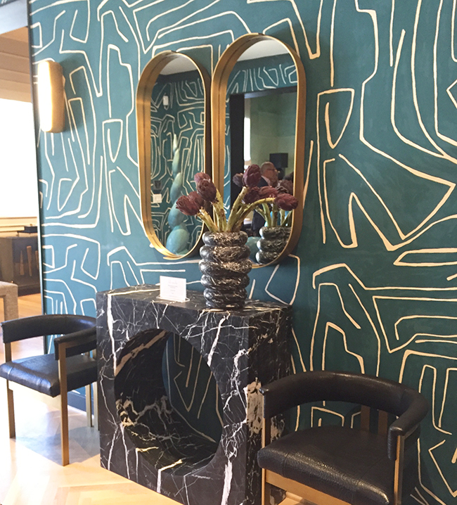 Kelly Wearstler furniture showroom with graphic wallpaper and modern brass mirrors 